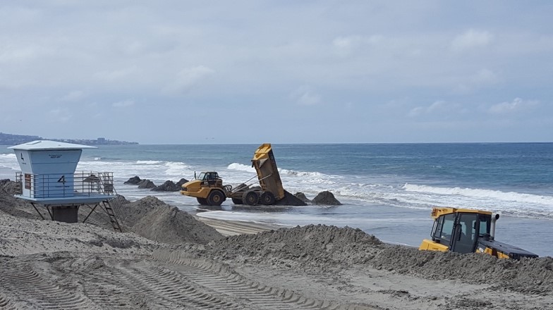 Disposing sand and cobbles along the waterline at Torrey Pines State Beach.  Photo by M. Hastings.